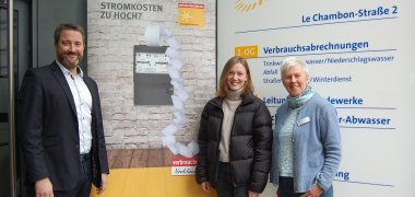 Bürgermeister Marco Diethelm, Klimaschutzmanagerin Caroline Hüttemann und Energieberaterin Brigitte Topmöller vor einem Werbeplakat der Verrbaucherzentrale