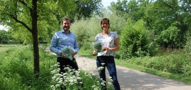 Bürgermeister Marco Diethelm und Gaby Höft präsentieren die Broschüre im Klostergarten Herzebrock die 