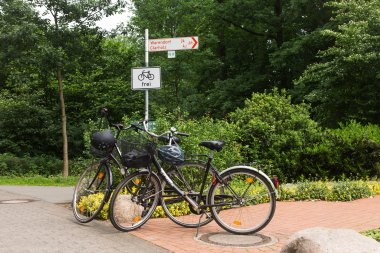 Fahrräder lehnen an einem Wegweiser